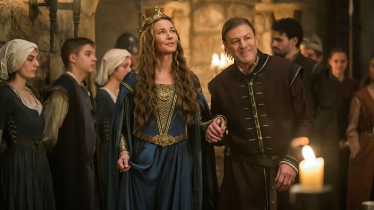 Sean Bean holds Connie Nielsen's hand while leading her around a banquet hall filled with staff