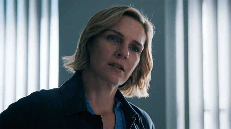 Carol standing up with her head tilted to the left in Pluribus episode 4