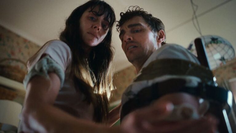 A couple looking down at one of their hands in Neon body horror movie Together