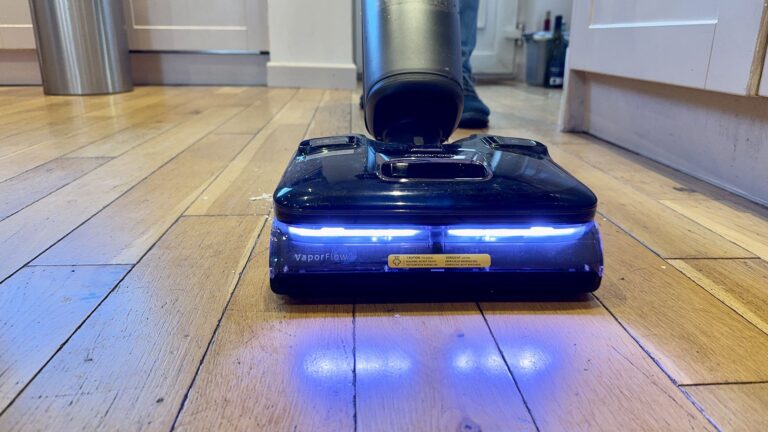 Roborock F25 Ultra clearing a mess of egg, oats, ketchup and more from an engineered wooden floor
