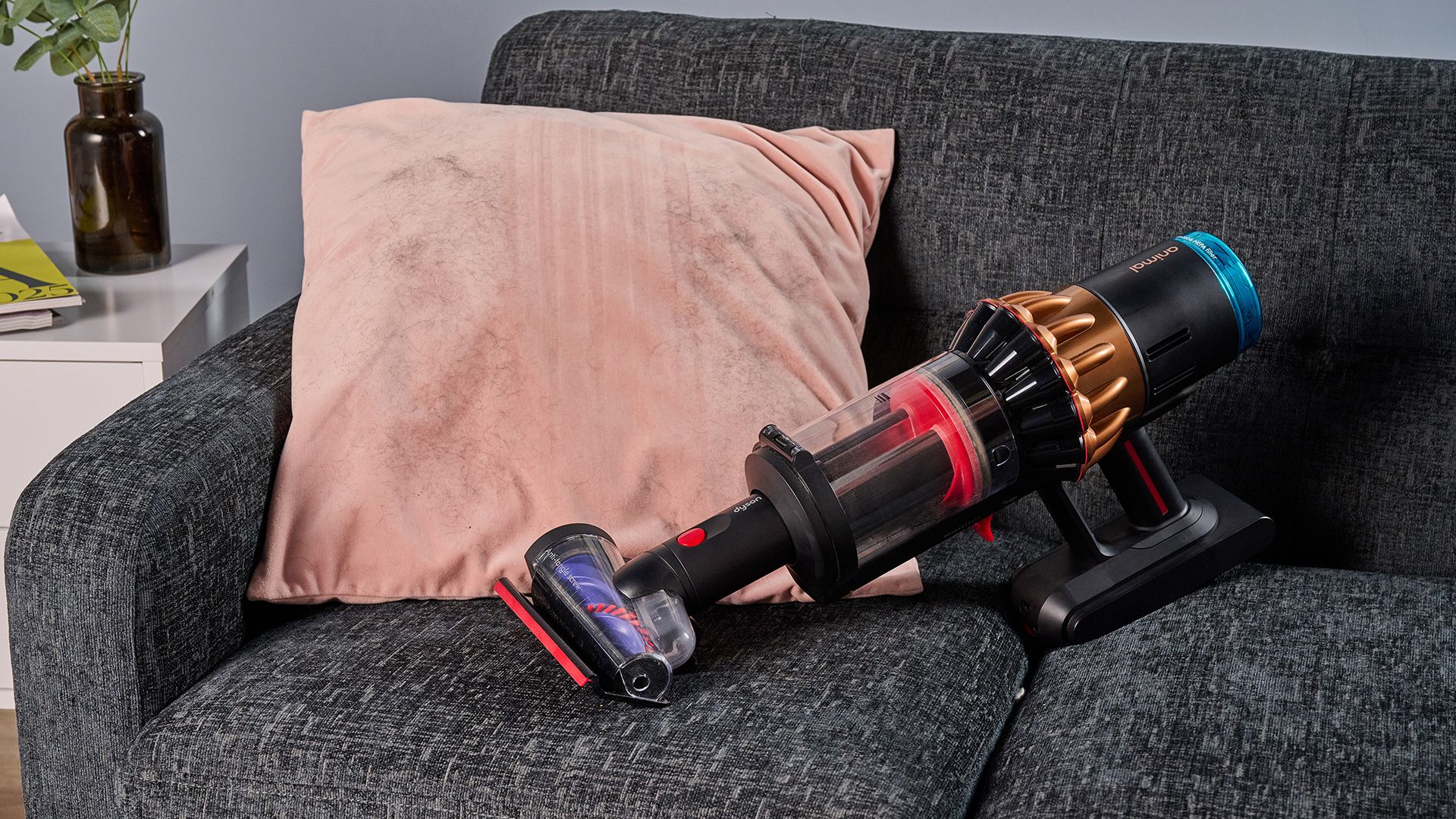 Dyson V16 Piston Animal vacuum with updated Hair screw tool, lifting pet hair from a velvet cushion