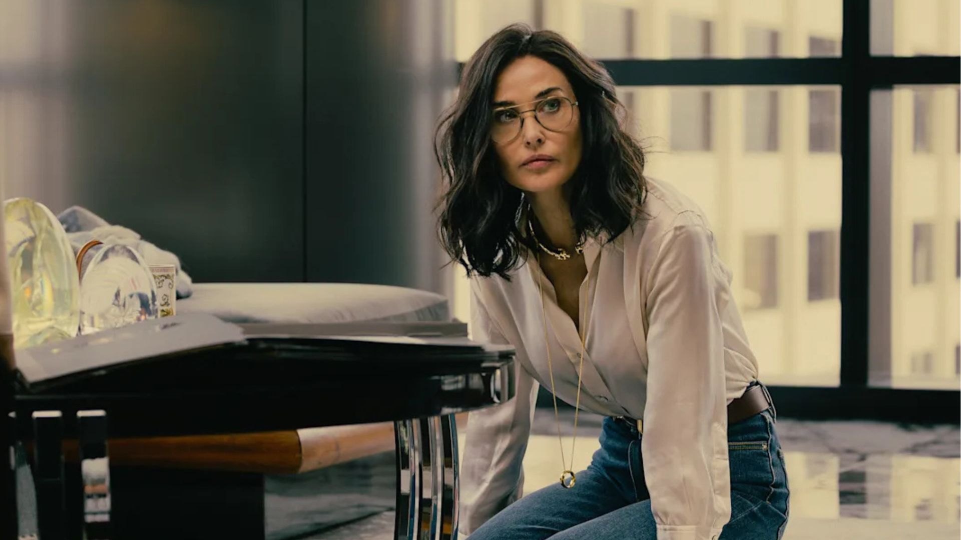 Cami kneels on the floor of Monty's office