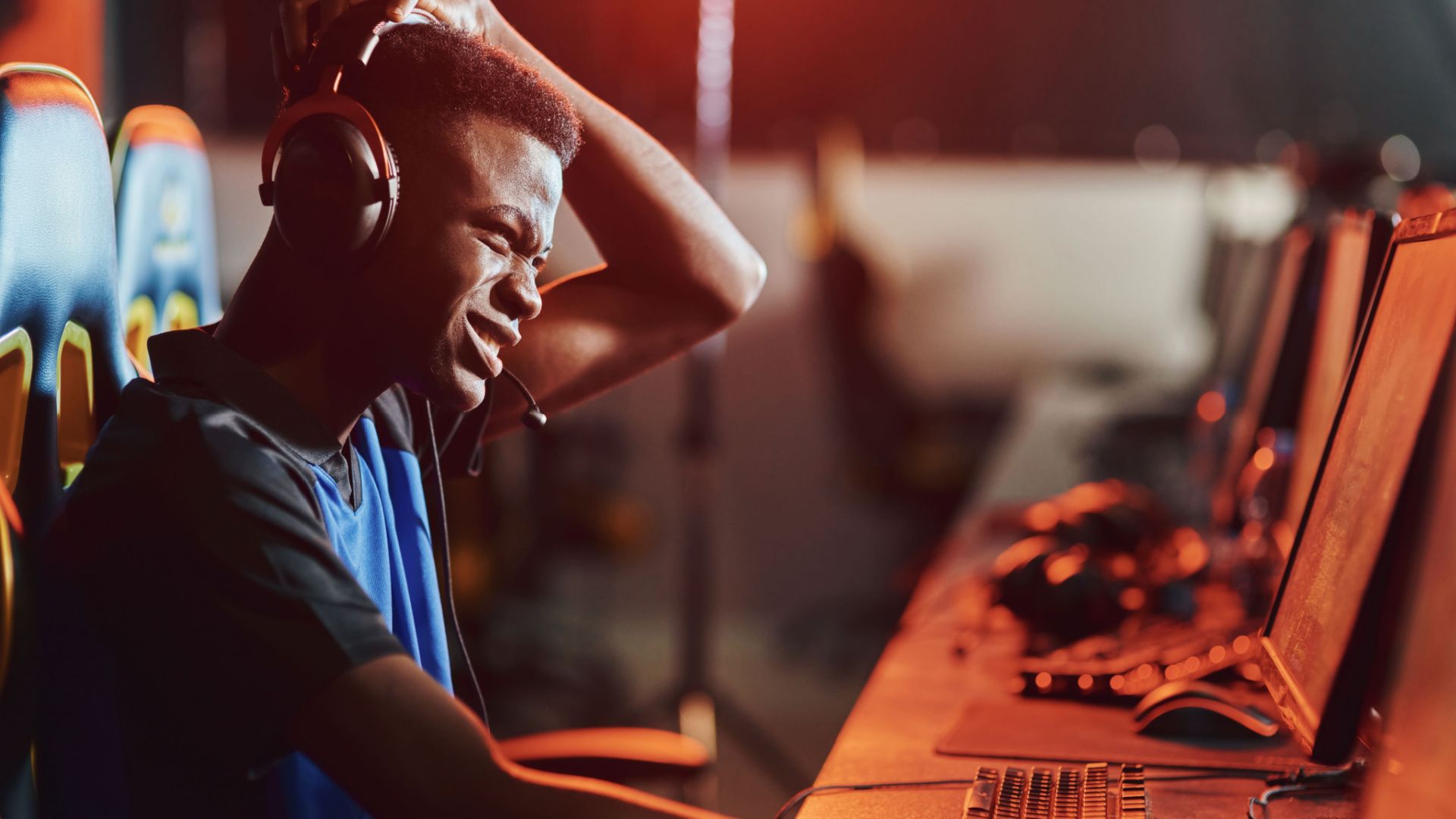 Confused looking PC gamer sitting at a gaming desktop PC