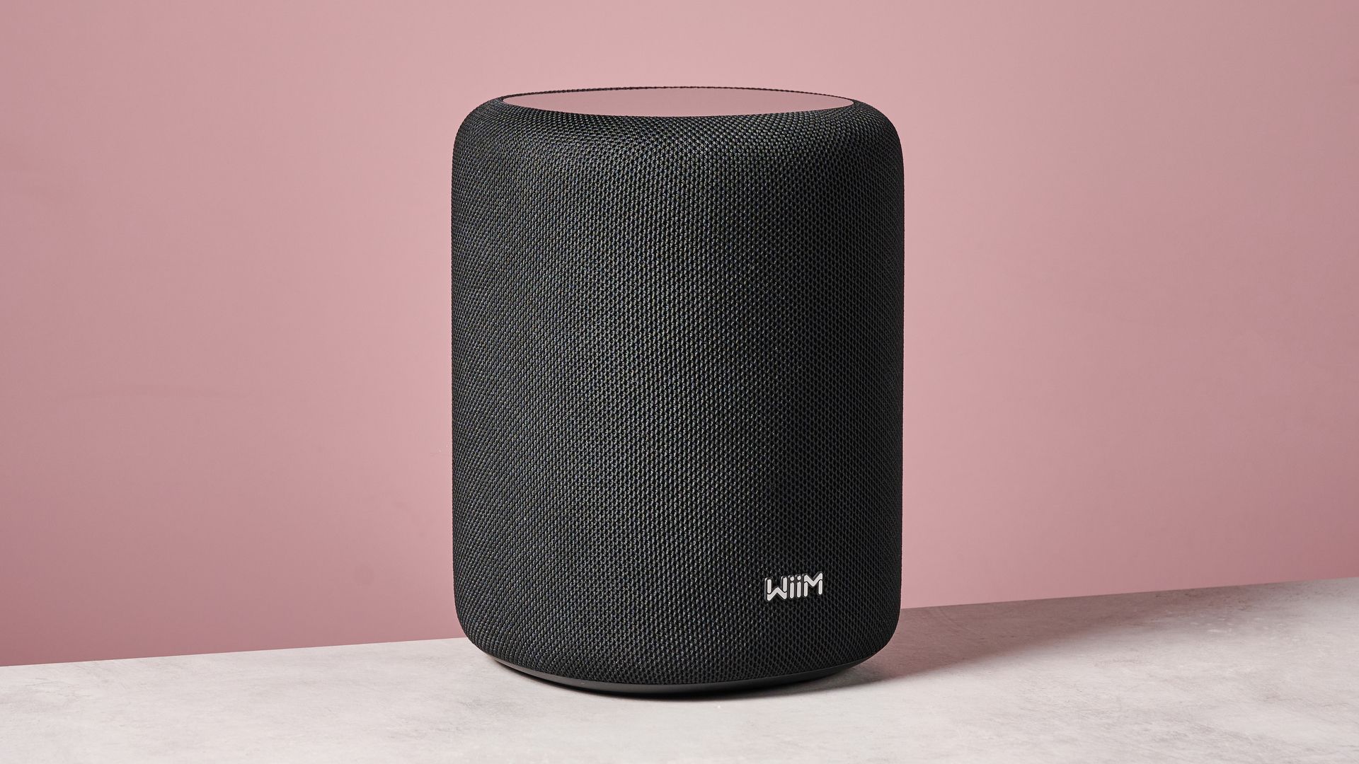 The WiiM Sound Lite at a 45 degree angle in front of a pink background.