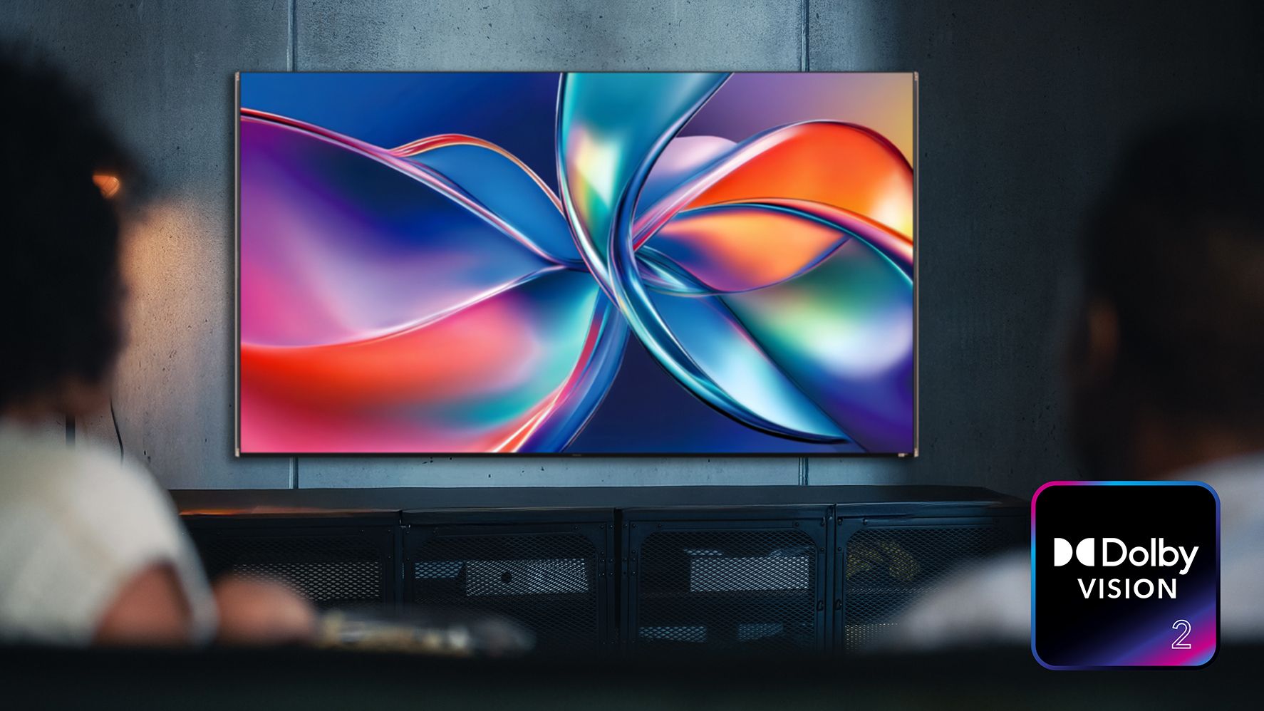 The Dolby Vision 2 logo, with a TV showing a colorful image, watched by a woman