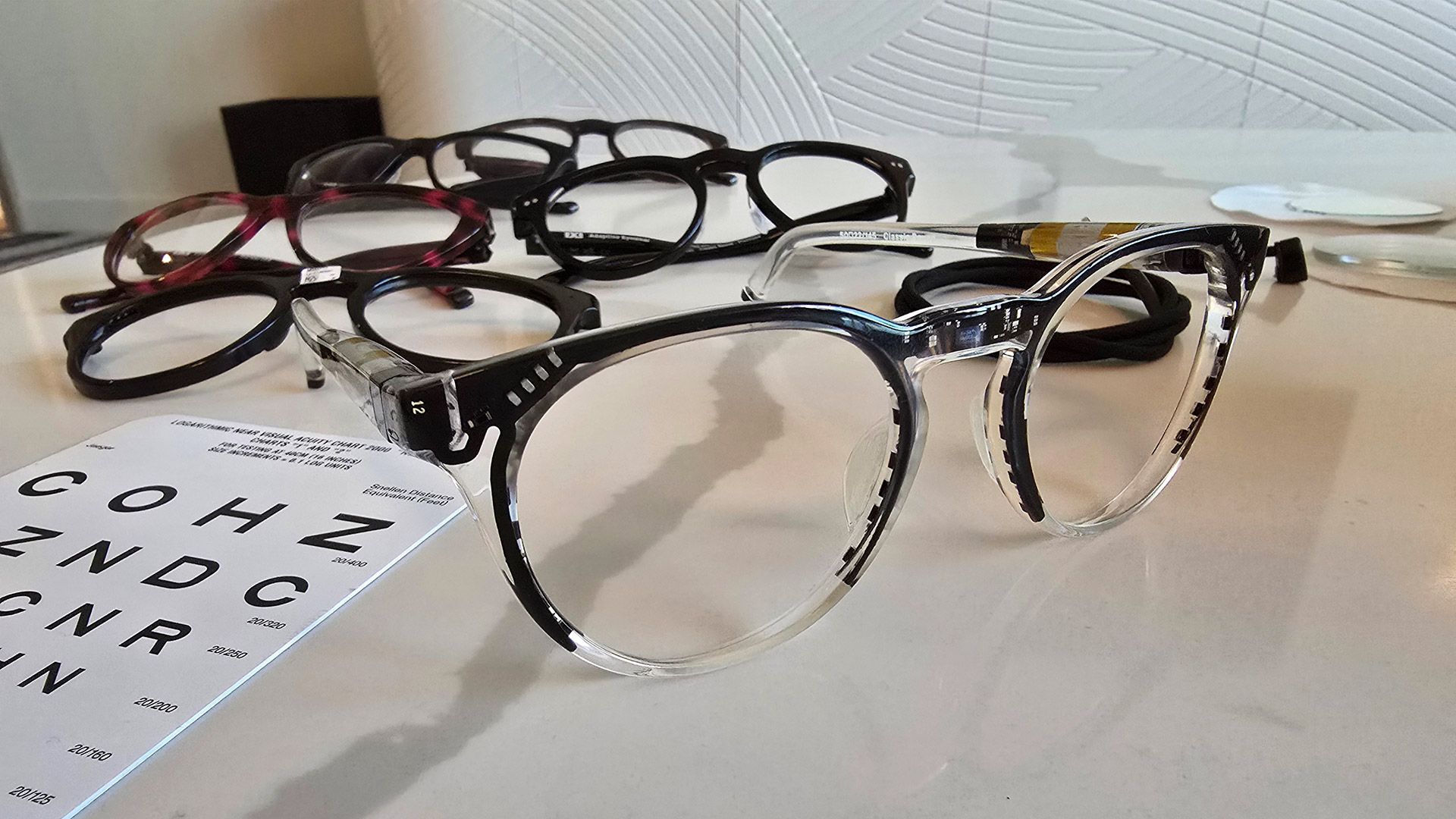 A prototype version of IXI's smart glasses is unpainted to reveal the components hidden within the frame. At back, the finished product.