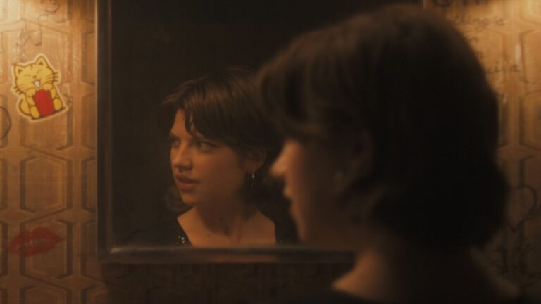 Bree's reflection looks away in the mirror