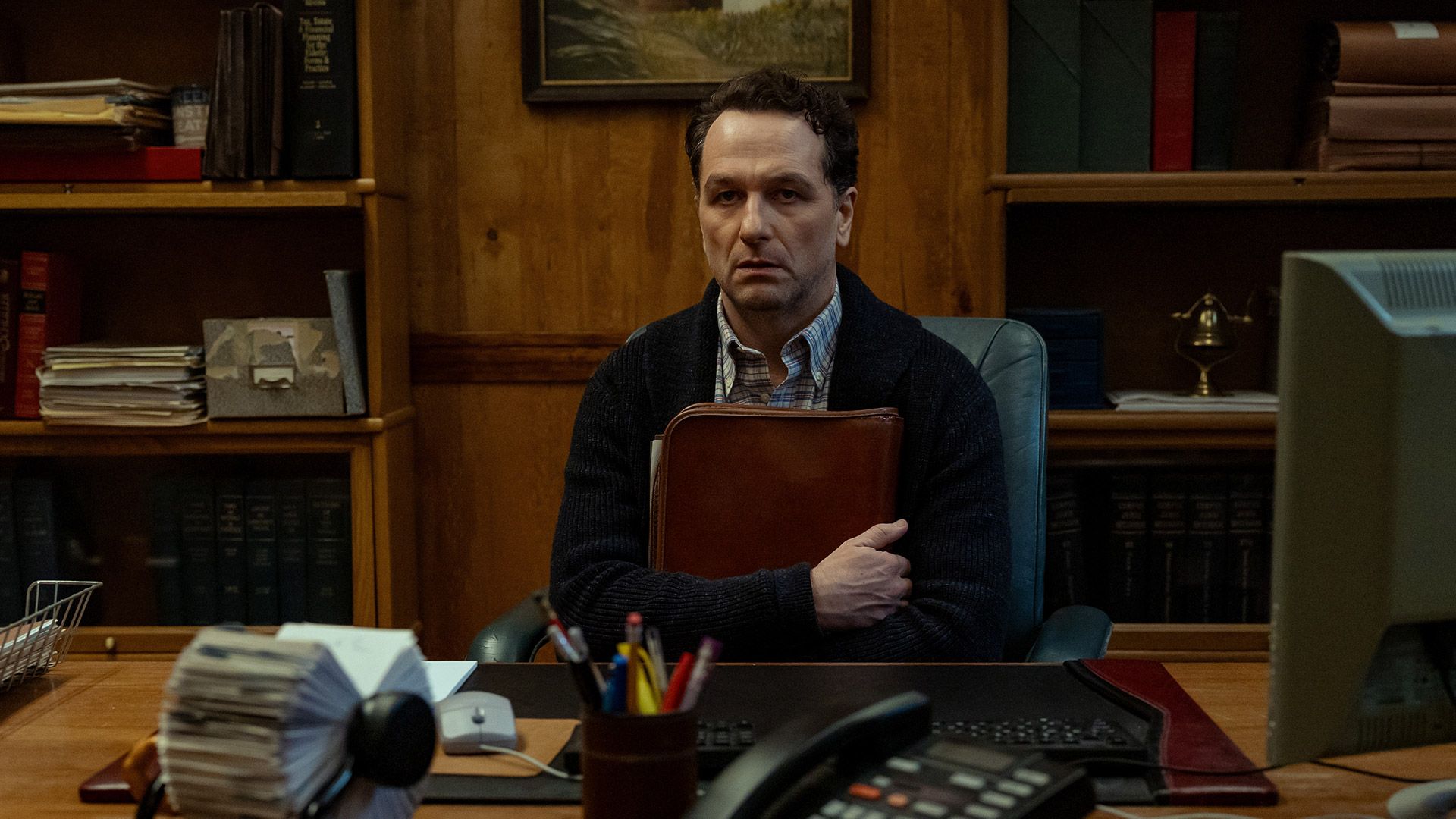 Matthew Rhys clutches a folder in a scene from the new Apple TV show Widow's Bay