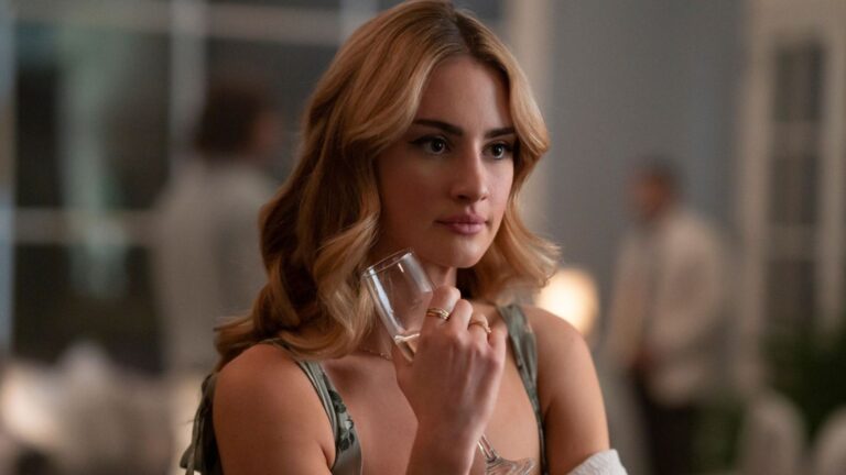 Lucy holds a champagne glass in her right hand