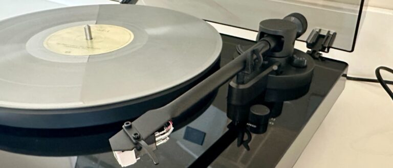 Philips Fidelio FT1 close-up showing the tonearm and a record on the plinth, on a white table 