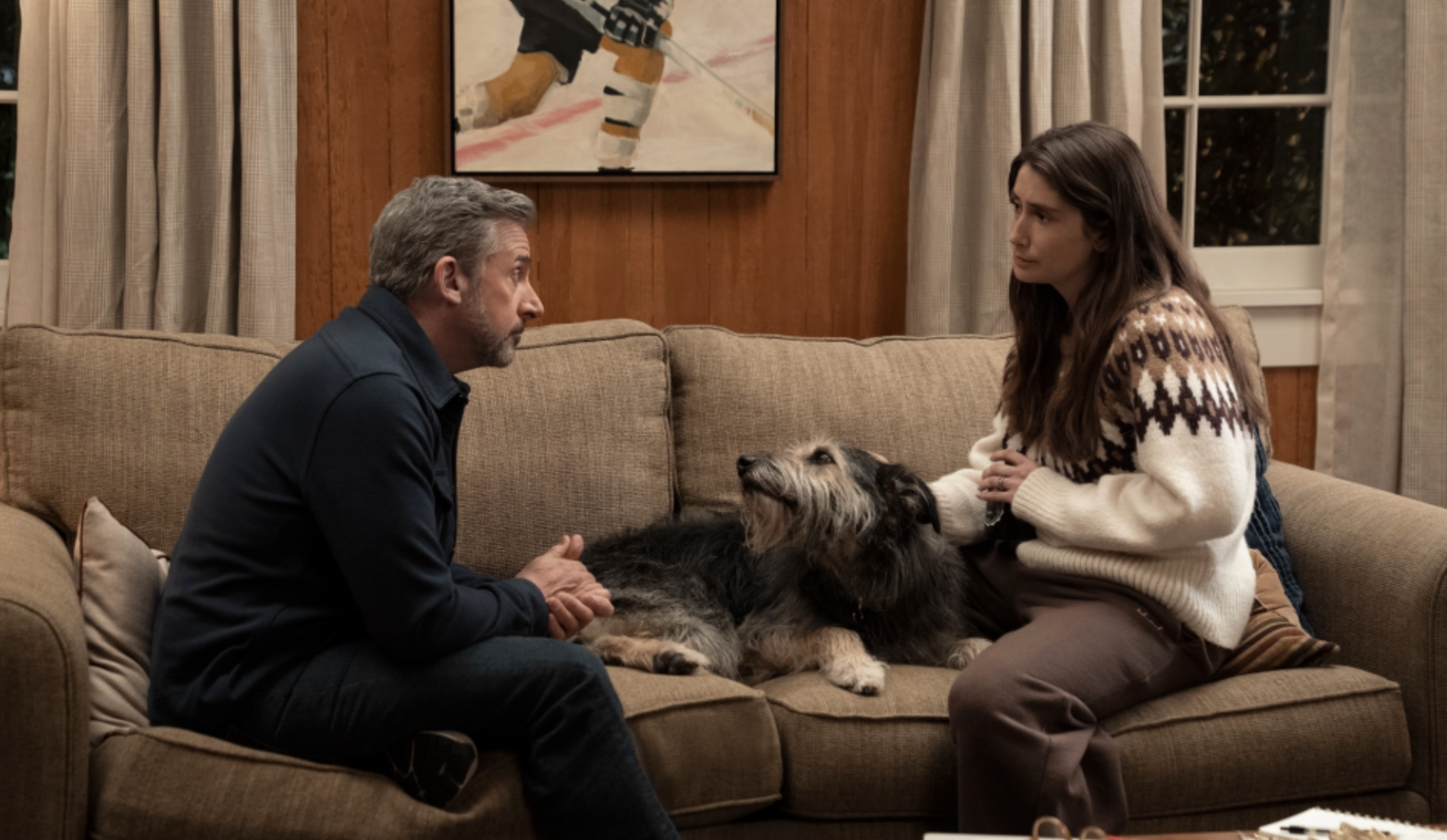 Steve Carell and Charly Clive sitting on a sofa with a dog between them in HBO's Rooster