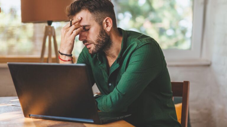 Man looking frustrated with his laptop