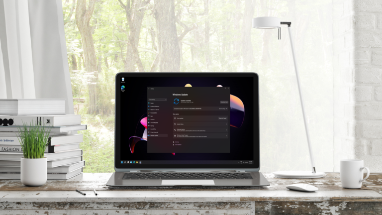 Windows 11 Update showing on laptop on a desk in front of a window