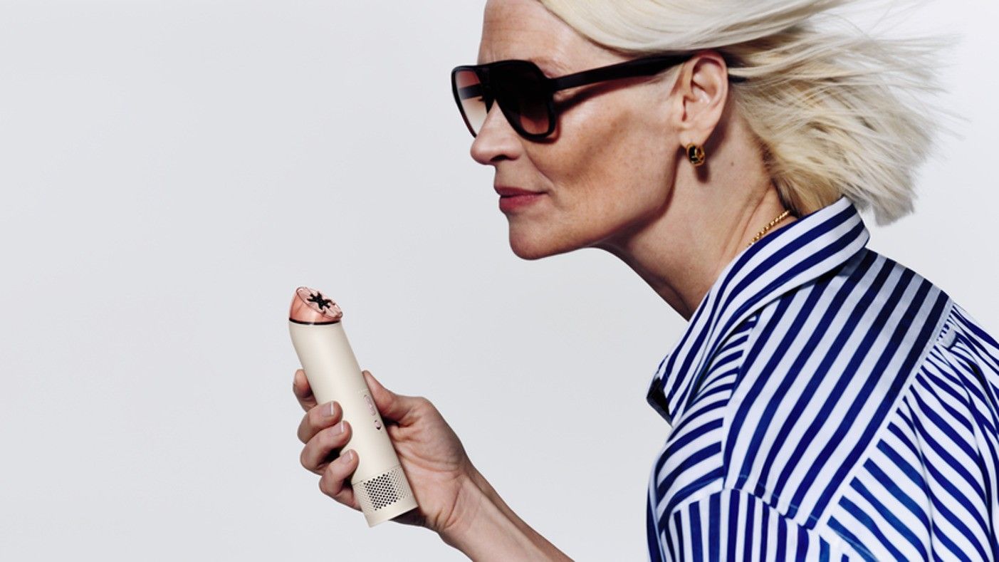 Woman holding white Dyson HushJet Mini Cool Fan