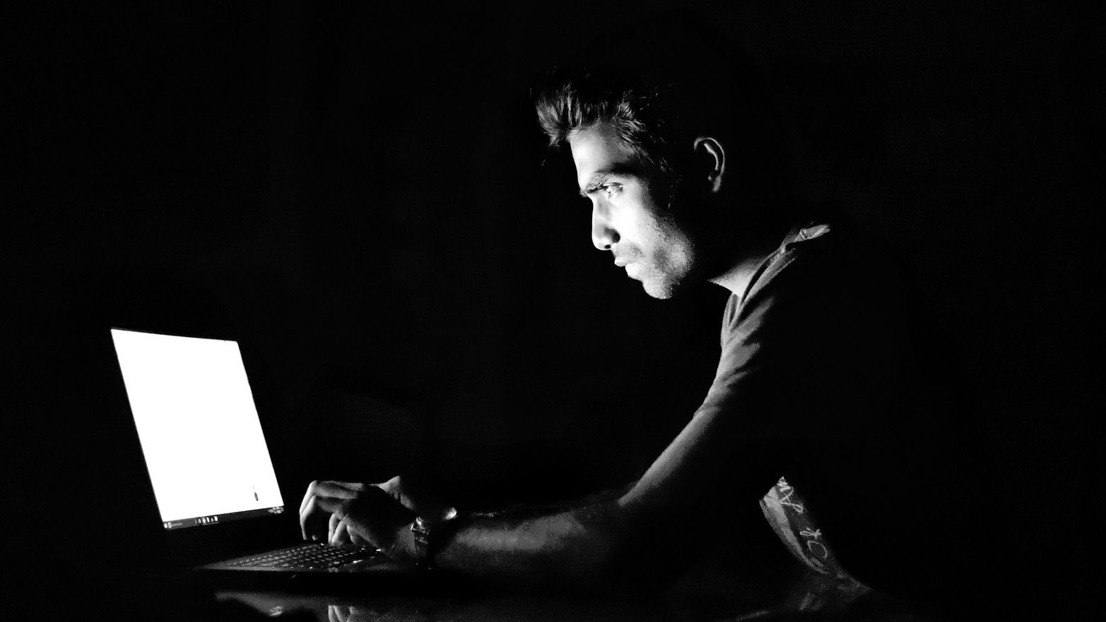 Am man on his laptop in the dark, accessing UFO and alien files anonymously