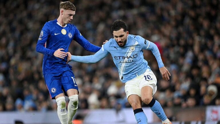 Cole Palmer and Rayan Cherki compete for the ball in a Premier League game.