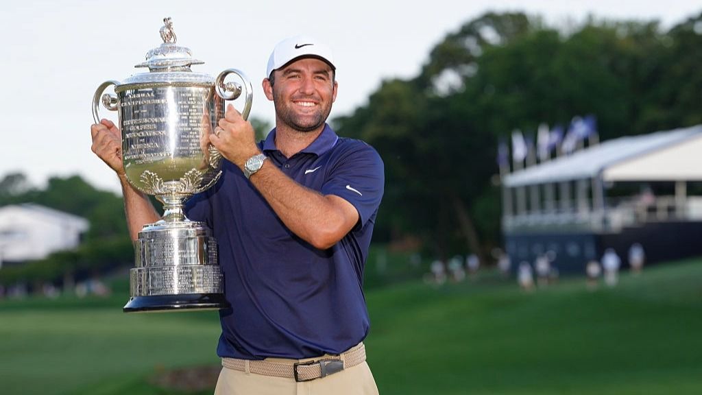 Scottie Scheffler raises the trophy aloft after winning the PGA Championship 2025