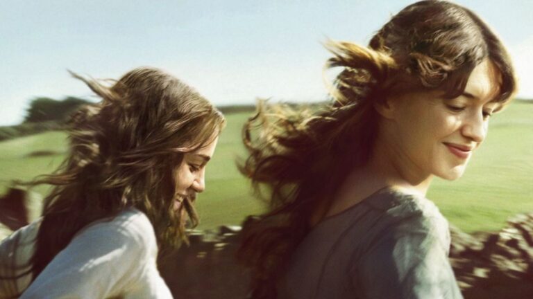 Two girls run through a field