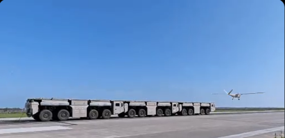 A screengrab from a social media post showing a drone flying off a modular truck-based catapult launch system