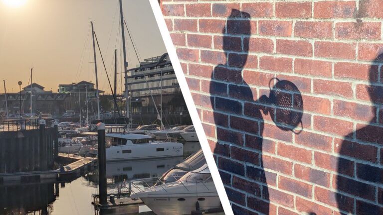 Boats in a marina at sundown during the 2026 solar eclipse, alongside a shadow on a wall of a person holding a colander