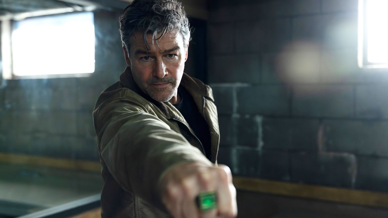 Hal Jordan aiming his right hand and Green Lantern ring at something off-screen in Lanterns