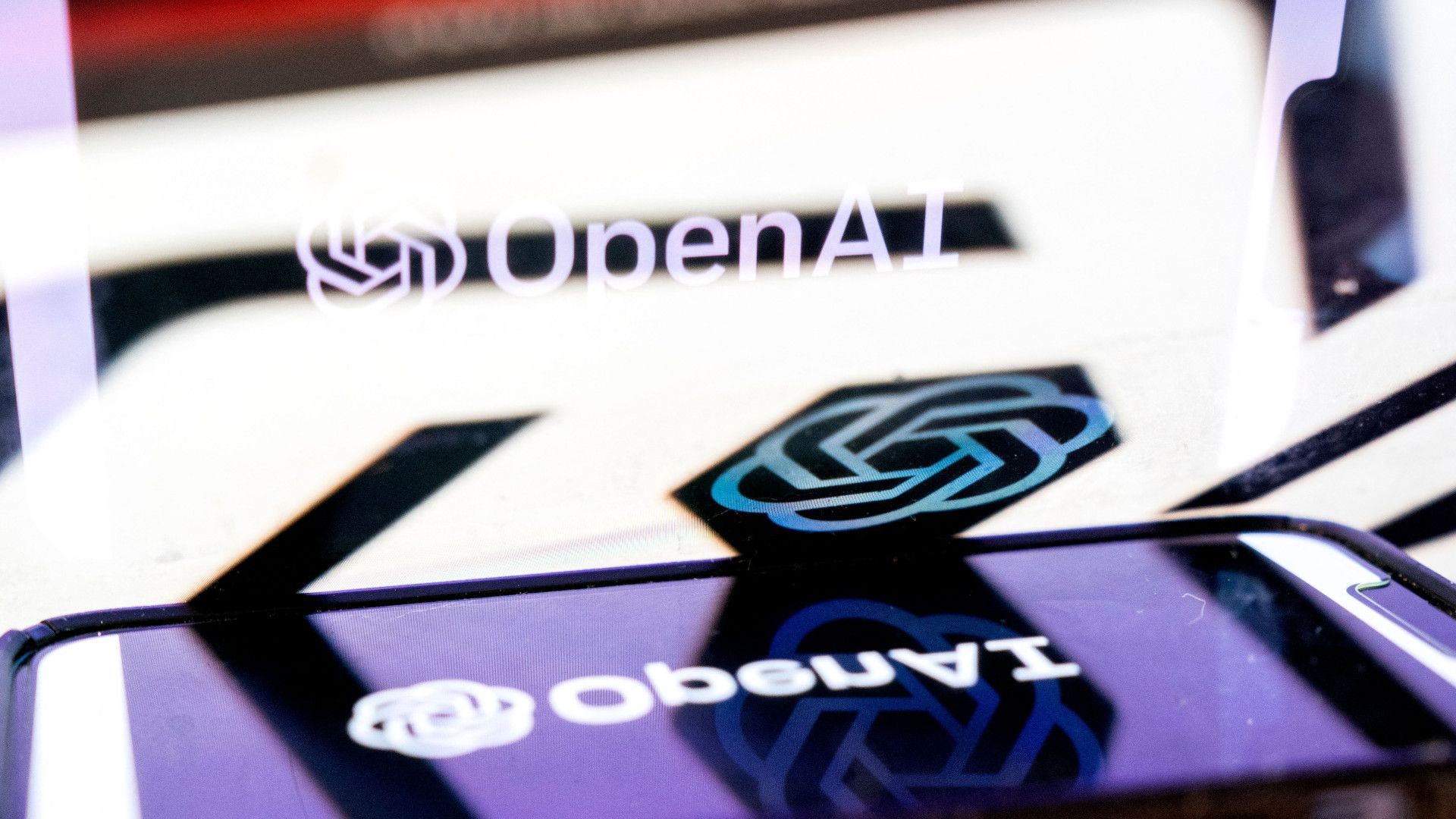 OpenAI logo on smartphone, reflected on main screen