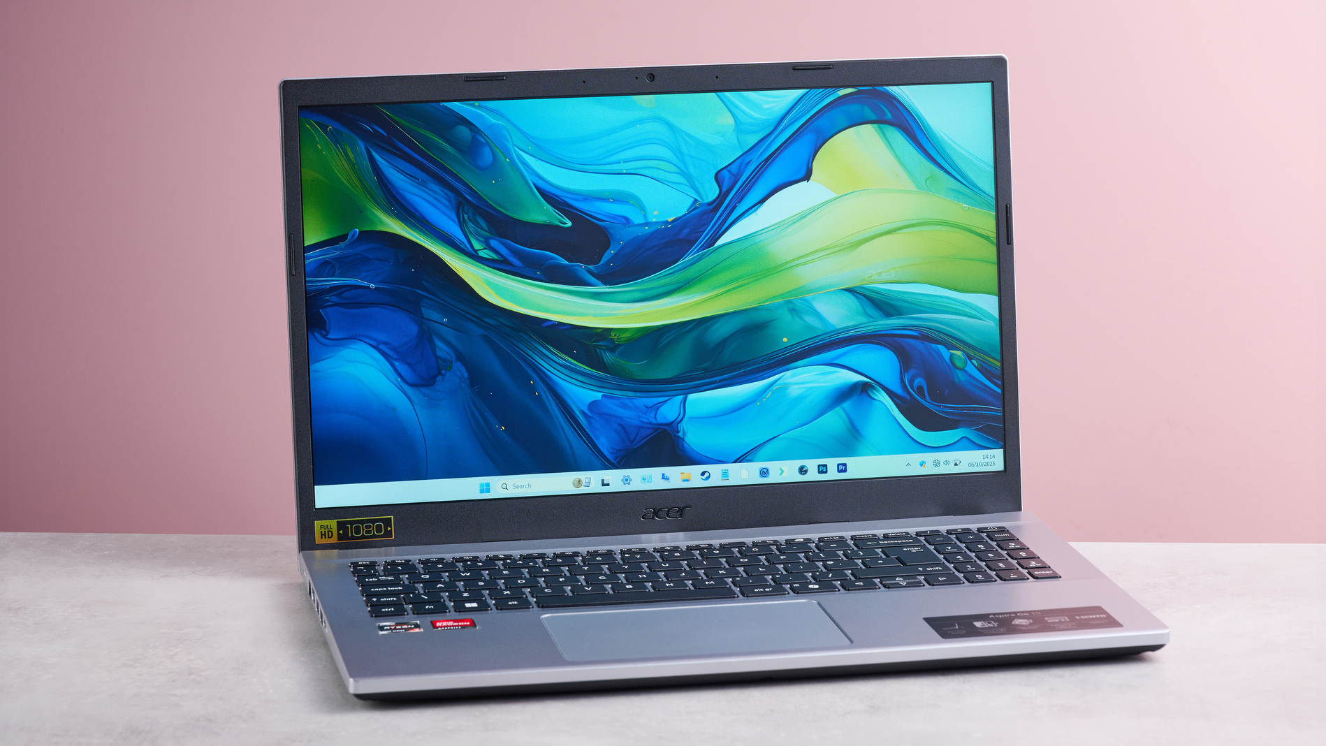 Three-quarter view of Acer Aspire Go 15 open on desk, with pink wall in background