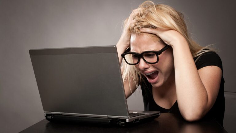 Angry woman using a Windows 11 laptop at a desk
