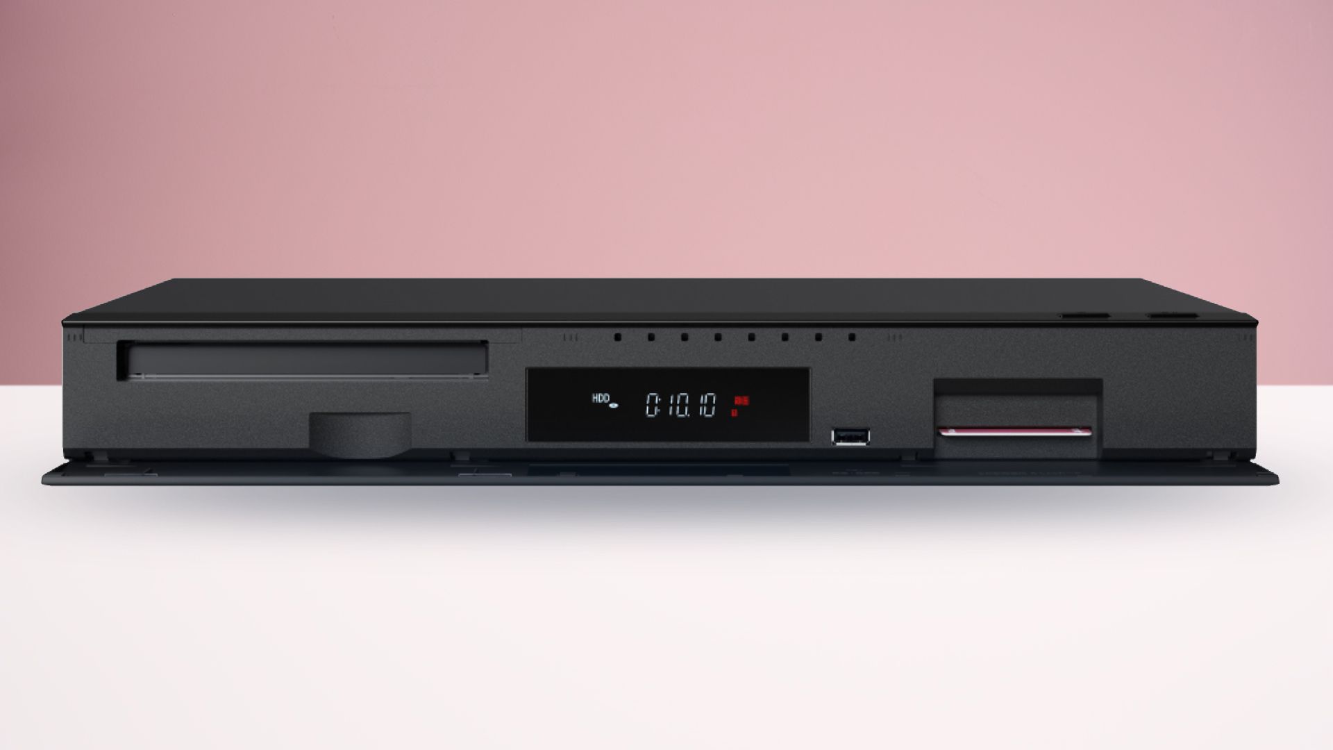 The Panasonic DMR-4X1010 Blu-ray player on a white surface with a pink background