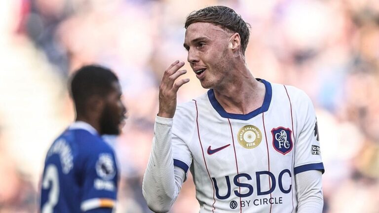 Cole Palmer, wearing Chelsea's white away kit, puts his hand to his mouth during a Premier League 2026/27 game.