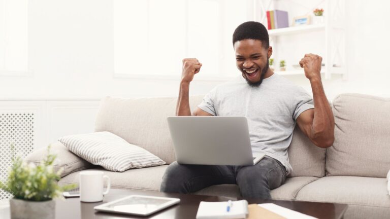 Happy man with a Windows 11 laptop on his lap