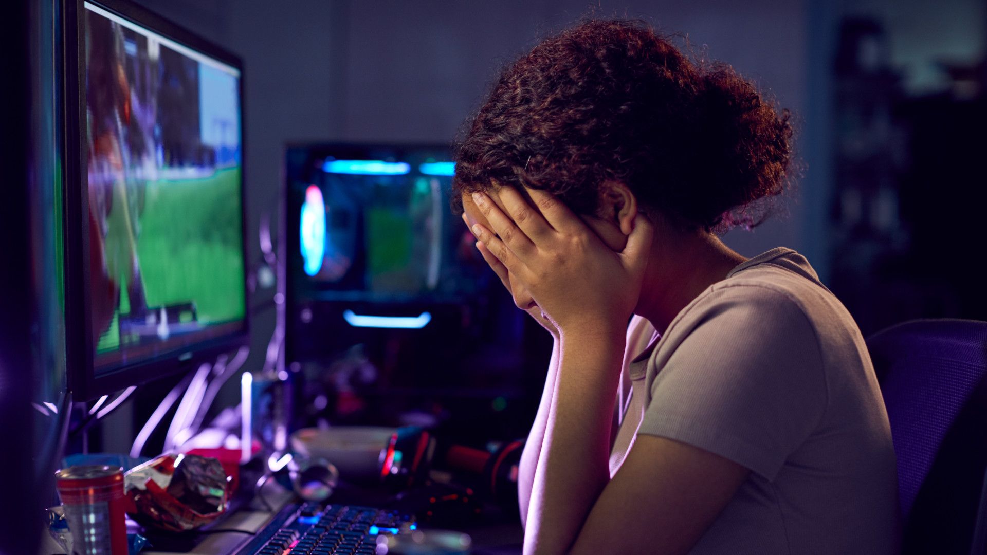 Gamer looking unhappy with her head in her hands