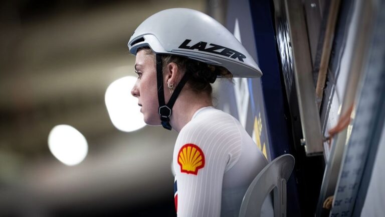 A side-on shot of Emma Finucane, wearing a cycling helment.